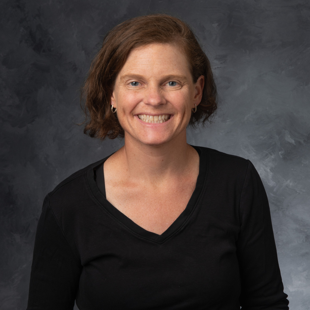 A photo of Dr. Voss smiling in front of a gray background