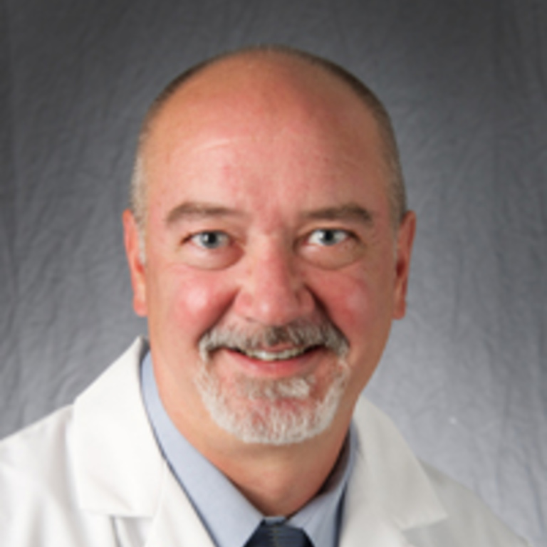 A photo of Dr. Steve Anderson wearing a white coat, blue shirt, and tie in front of a gray background